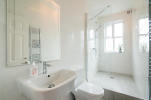 a white bathroom with a sink and a toilet at Burton House Boutique Flat in Manchester +18 photos
