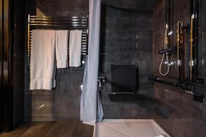a bathroom with a shower and a bath tub at Camden Enterprise Hotel in London