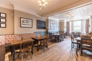a restaurant with tables and chairs and a chalkboard at The George Hotel in Castletown
