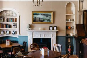 a dining room with a fireplace and tables and chairs at The George Hotel in Castletown