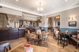 a restaurant with tables and chairs and a bar at The George Hotel in Castletown