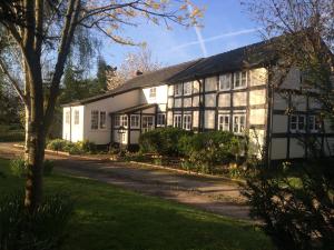 Una casa blanca y negra con un árbol delante. en Yew Tree Cottage en Leominster