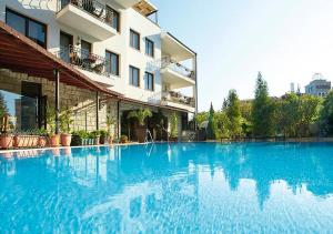 a large swimming pool in front of a building at Villa Maria Revas in Sunny Beach