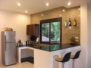 cocina con encimera y nevera en Leelawadee Garden Resort, en Ao Nam Mao