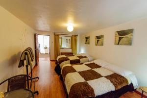 a hotel room with two beds and a window at Apartment & Rooms Cusco in Cusco