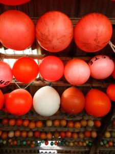 a bunch of red and white lanterns on a wall at Country Camp camping de Kooiplaats in Schiermonnikoog