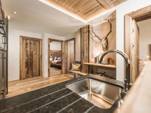 a kitchen with a sink and a living room at Hotel Bergkristall Zillertal in Hippach