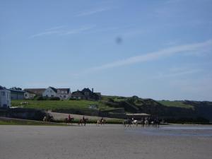 a group of people riding horses on the beach at Chez Isa in Saint-Martin-Boulogne