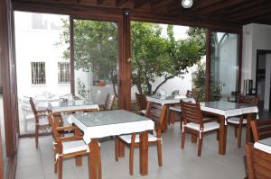 un comedor con mesas, sillas y ventanas en Melis Pansiyon, en Bodrum City