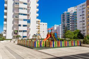 a playground in a city with tall buildings at Spot Rocha Prime in Portimão