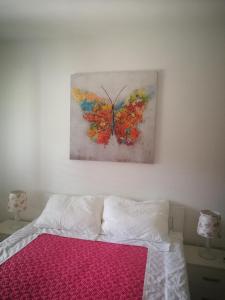 1 dormitorio con 1 cama con una pintura de mariposa en la pared en Apartments La Dolce Vita en Herceg-Novi