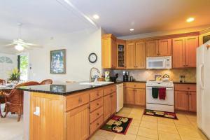 a kitchen with wooden cabinets and a white refrigerator at Regency at Poipu Kai #914 in Koloa