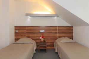 two twin beds in a room with a wall at Logis Hôtel Restaurant L'Europe in Marvejols