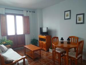 ein Wohnzimmer mit einem Tisch und einem TV in der Unterkunft El Passeig in Vilafames