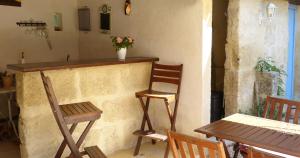 - un bar avec une chaise en bois, une table et des chaises dans l'établissement Mas des Bougainvillees, à Sernhac
