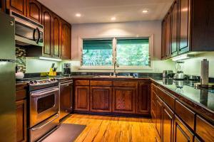uma cozinha com armários de madeira e uma janela em Kauai Tree House em Wainiha