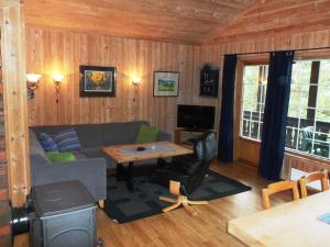 a living room with a couch and a table at Hogstul Hytter - Knatten - 3 Bedroom Cottage in Tuddal