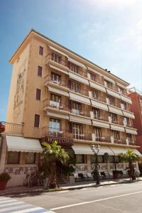 un gran edificio de apartamentos en el lateral de una calle en Hotel Corso Alaxi Hotels, en Alassio