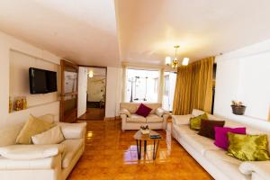 sala de estar con 2 sofás y TV en Apartment & Rooms Cusco en Cusco