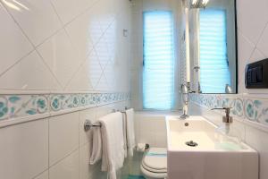 a white bathroom with a sink and a toilet at Riccardo Condotti Suite in Rome +29 photos