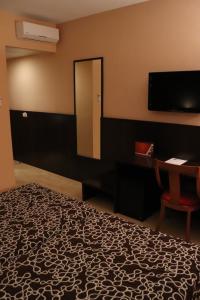 1 dormitorio con cama, espejo y escritorio en Hotel Acosta Ciudad de la Música, en Villafranca de los Barros