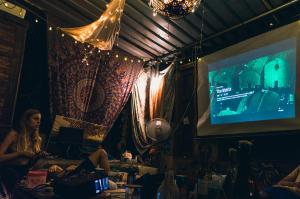 a woman sitting in a room watching a television at Wonderland Hostel in Anjuna