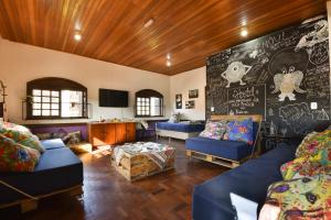 a living room with blue couches and a chalkboard at Hostel Chocolatchê in Gramado