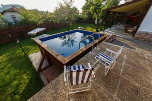 a swimming pool with two chairs and a table at Villa Rose in Belogradchik