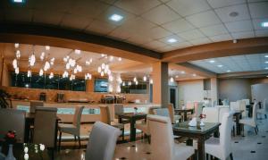 un ristorante con tavoli e sedie e un bar di Tskaltubo Hotel Prometheus a Tskhaltubo
