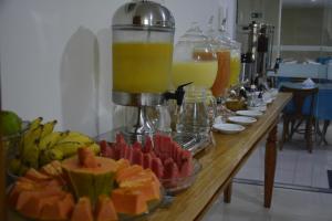a buffet of juice and fruit on a table at San Marino Hotel in Rio Pomba