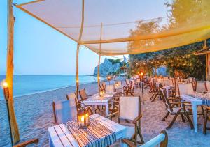 a beach area with tables, chairs and umbrellas at Thracian Cliffs Golf & Beach Resort in Kavarna