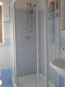 een douche met een glazen deur in de badkamer bij dgs palinuro in Palinuro