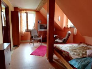 a bedroom with orange walls and a bed and chairs at Agroturystyka Giże in Giże