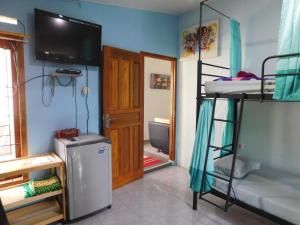 a room with two bunk beds and a television at Belitung Backpacker in Tanjungpandan