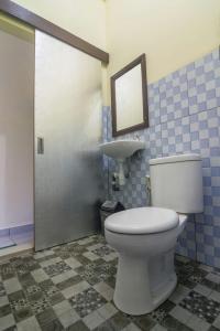ein Badezimmer mit einem weißen WC und einem Waschbecken in der Unterkunft Tanaya Homestay in Amed