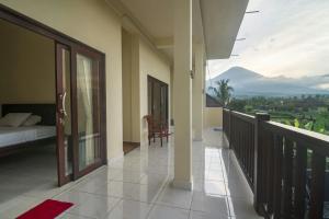 a room with a balcony with a bed and a view at Tanaya Homestay in Amed
