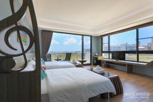 馬公市にあるPon Pon Wu Homestayのベッド2台と大きな窓が備わるホテルルームです。