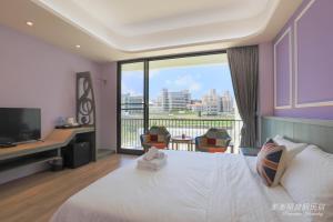 a hotel room with a bed and a large window at Pon Pon Wu Homestay in Magong