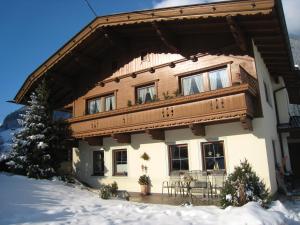 a house in the snow with a balcony at Appartements Familie Eberharter in Finkenberg