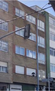 un semáforo frente a un edificio de ladrillo en Apartamento Naron, en Narón
