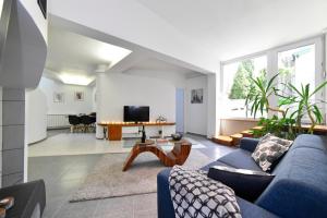 a living room with a blue couch and a table at Apartment with fireplace and terrace in Zagreb
