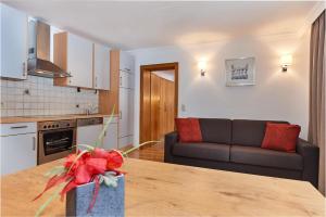 uma cozinha e sala de estar com uma mesa e um sofá em Apartments Neue Post em Filzmoos