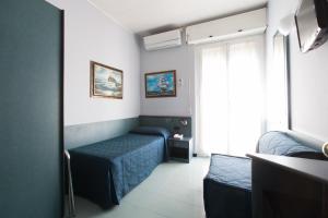 a small room with two beds and a window at Hotel Tirreno in Genoa
