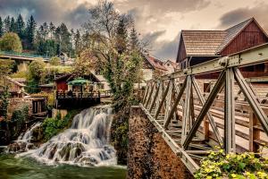 un puente sobre un río con una cascada en Rooms Daniela, en Slunj