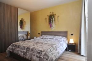 Un dormitorio con una cama y dos espejos en la pared. en La Casa dei Nonni sul Garda, en Peschiera del Garda