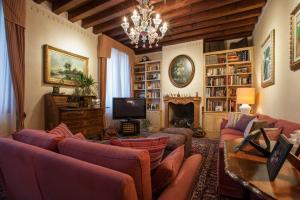 sala de estar con sofás, TV y chimenea en Villa Irene en Casale sul Sile
