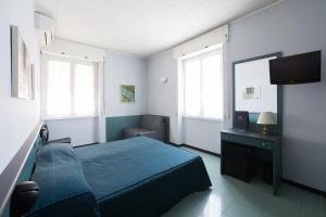 a bedroom with a blue bed and a chair at Hotel Tirreno in Genoa