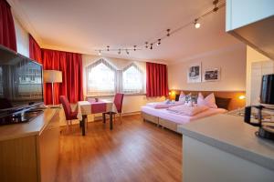 ein Hotelzimmer mit 2 Betten und einem Esstisch in der Unterkunft Apartments Neue Post in Filzmoos