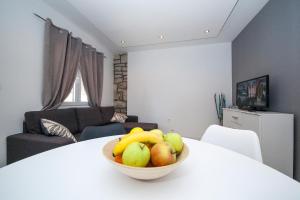eine Schale mit Obst auf einem weißen Tisch im Wohnzimmer in der Unterkunft Apartments and Mobile Homes Makarska in Makarska