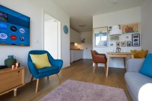 ハイリゲンハーフェンにあるHeiligenhafenbudeのリビングルーム(青い椅子、テーブル付)